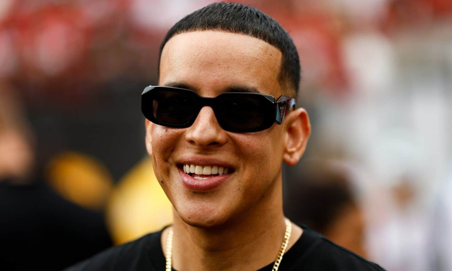 Dady Yankee utilizando lentes de sol y sonriendo
