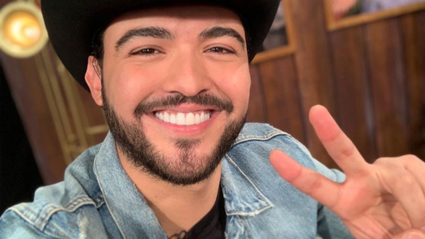 Alan Mora sonriendo y haciendo el sigo de paz con sus dedos
