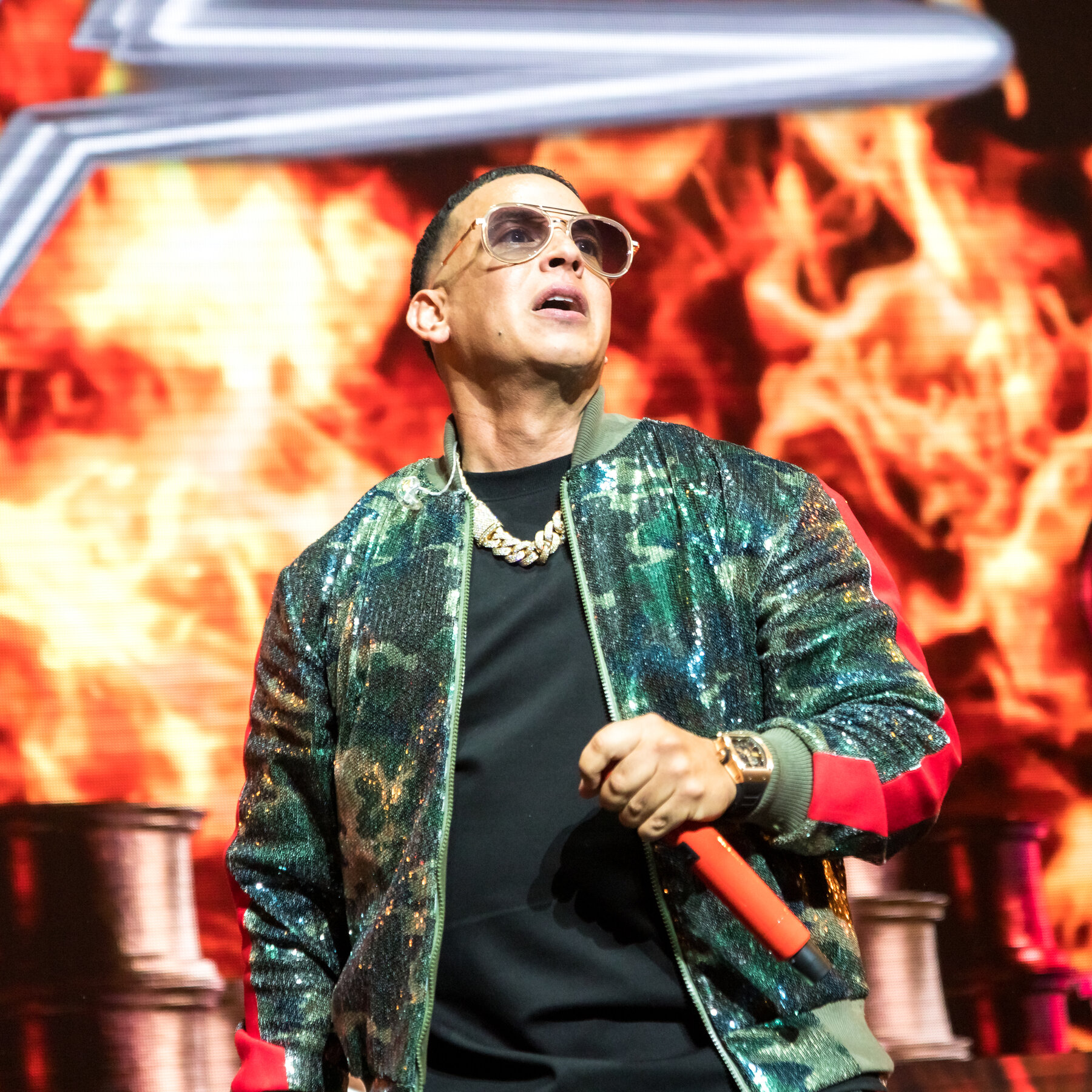 Daddy Yankee en conciero sosteniendo un micrófono en sus manos