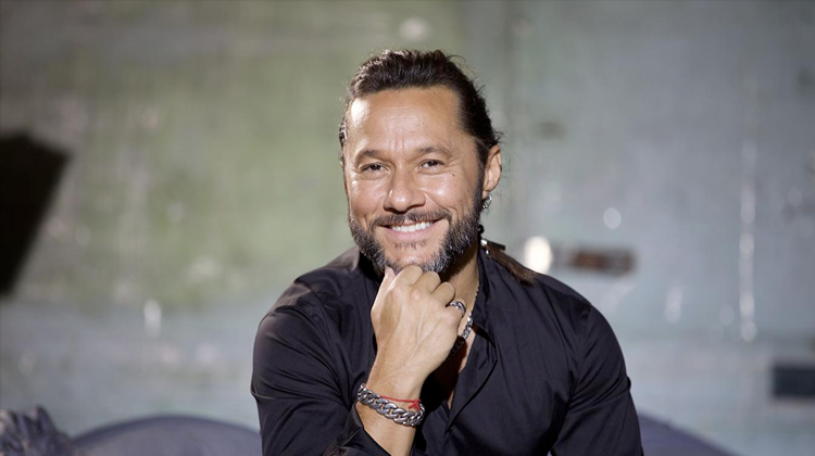 Diego Torres sosteniendo su barbilla con su puño y sonriendo 
