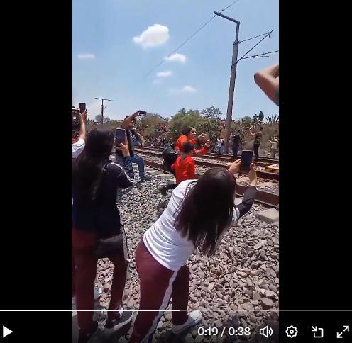 Personas grabando el paso de la locomotora por el municipio