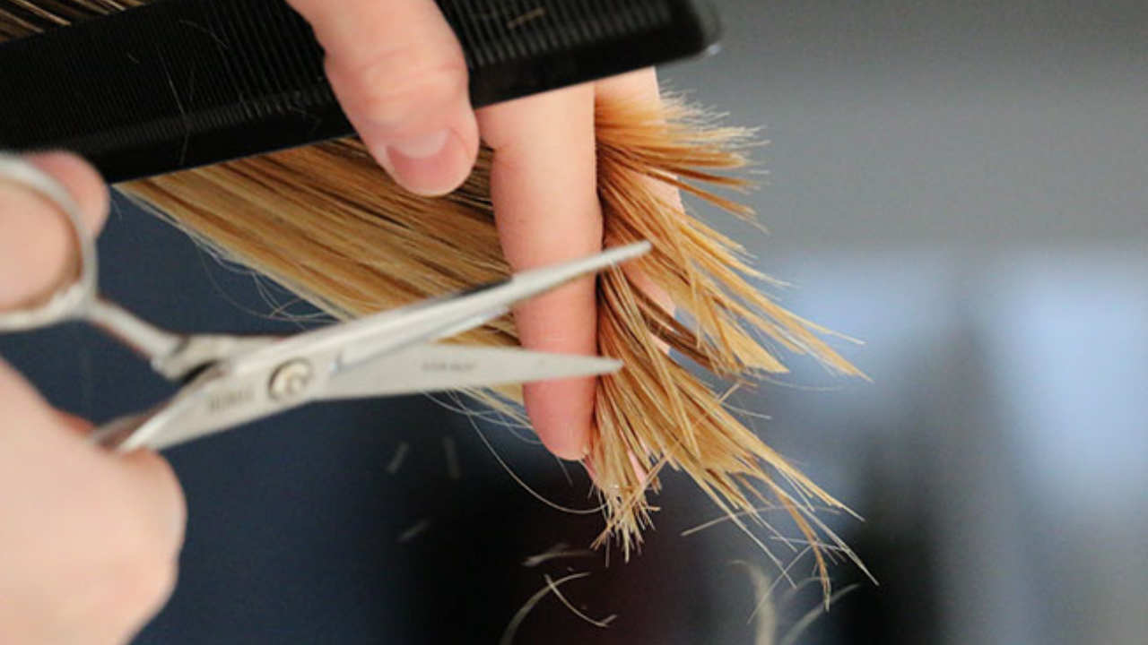 mujer cortándose el pelo
