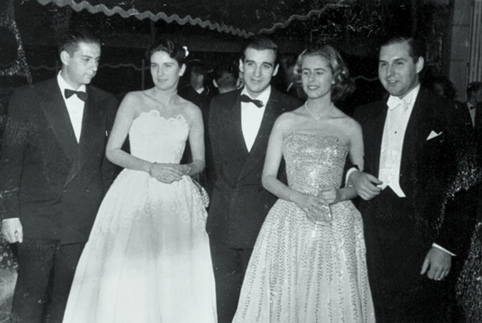 Mary Rose McGill con vestido brillante acompañada de caballeros y una mujer vestida de novia.
