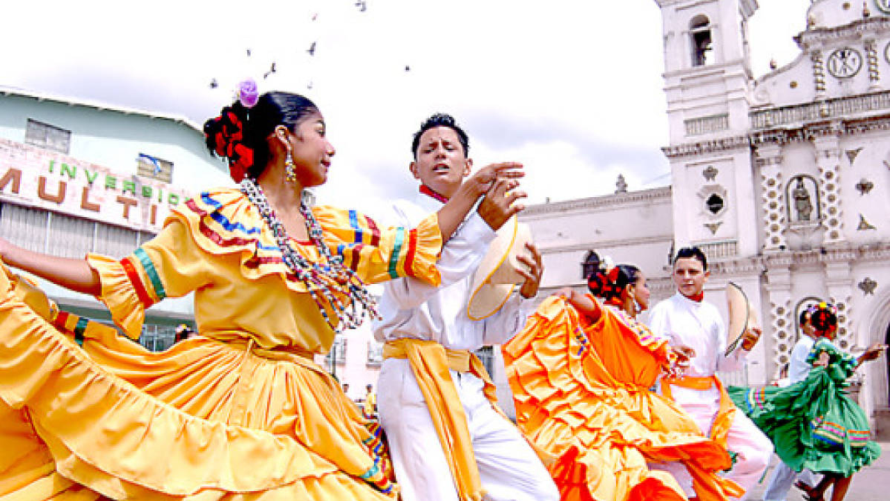 personas bailando en un parque, con Trajes típicos.
