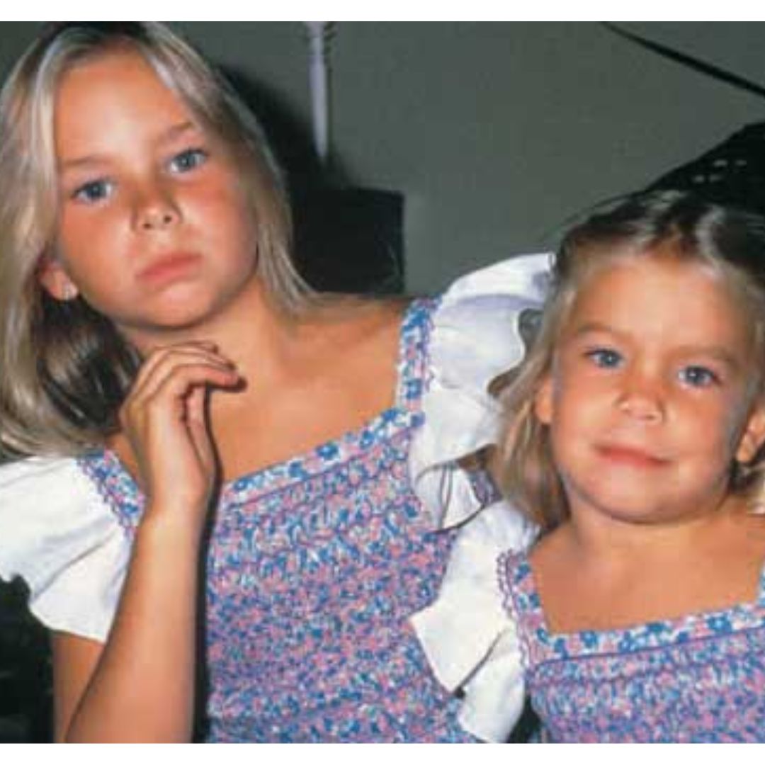 Caritina junto a su hermana Carla Goyanes de jovenes o niñas con vestidos de flores azules.