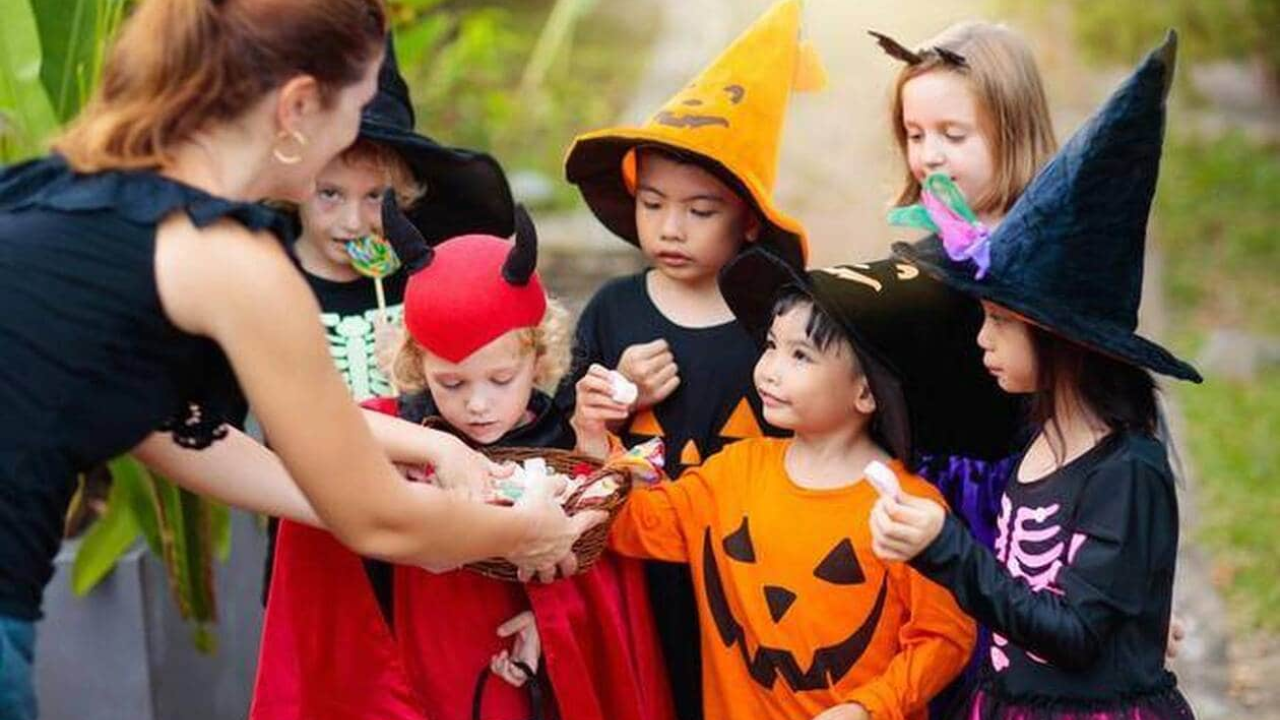 Niños vestidos de diferentes personajes de Halloween, con color anaranjado, negro y rojo.