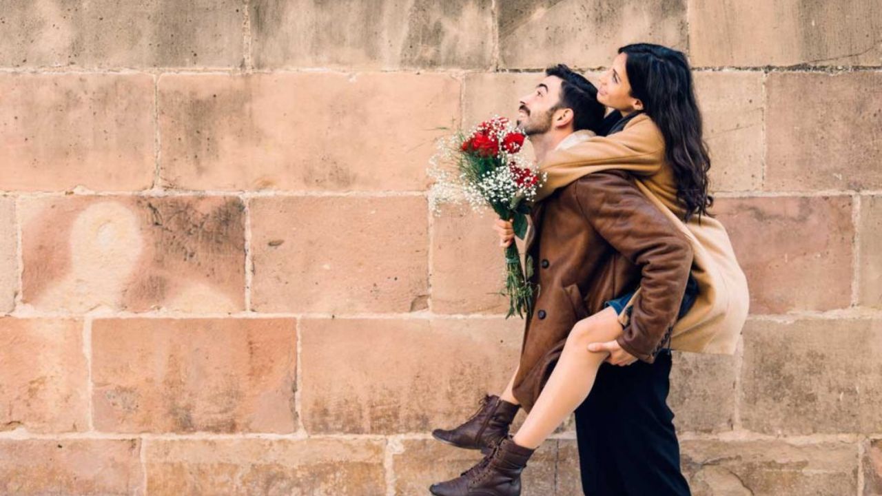 pareja de enamorados caminando con ramo de rosas rojas
