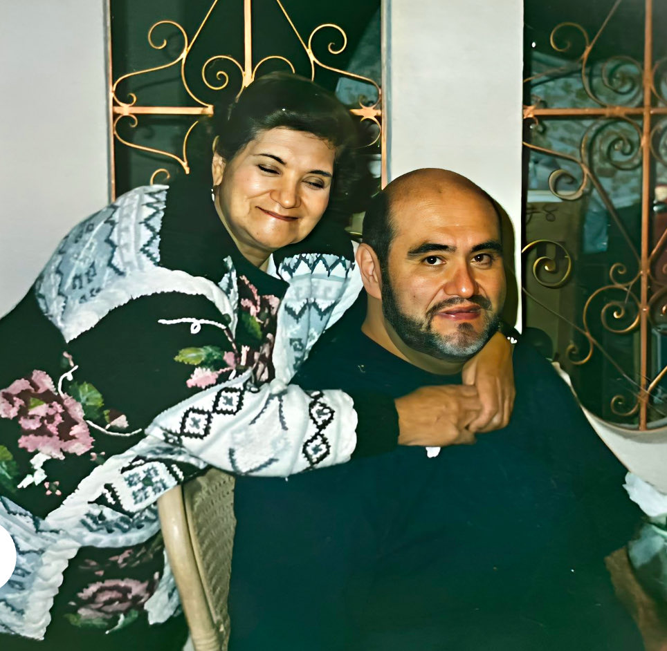 Elia Villanueva Falcón junto a su hijo Edgar Vivar, abrazándolo con una camisa blanca y negra 