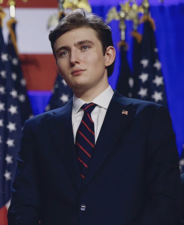 Barron Trump, vestido con un smoking azul marino y una corbata a rayas rojas