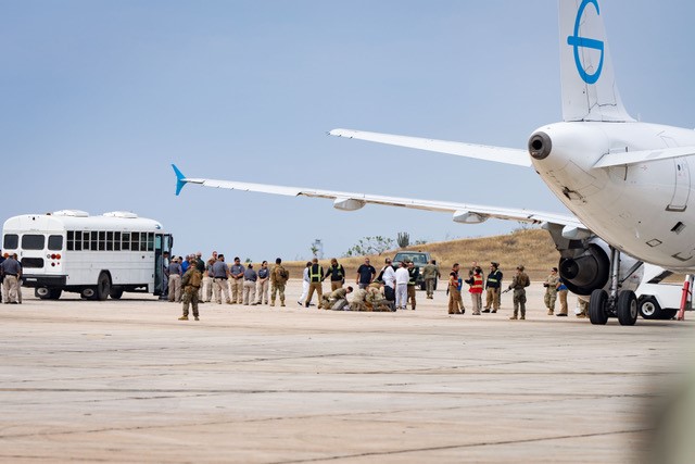 Migrantes subiéndose a un avión.