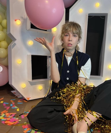 Jennette McCurdy con un globo color rosado y está sentada en el piso