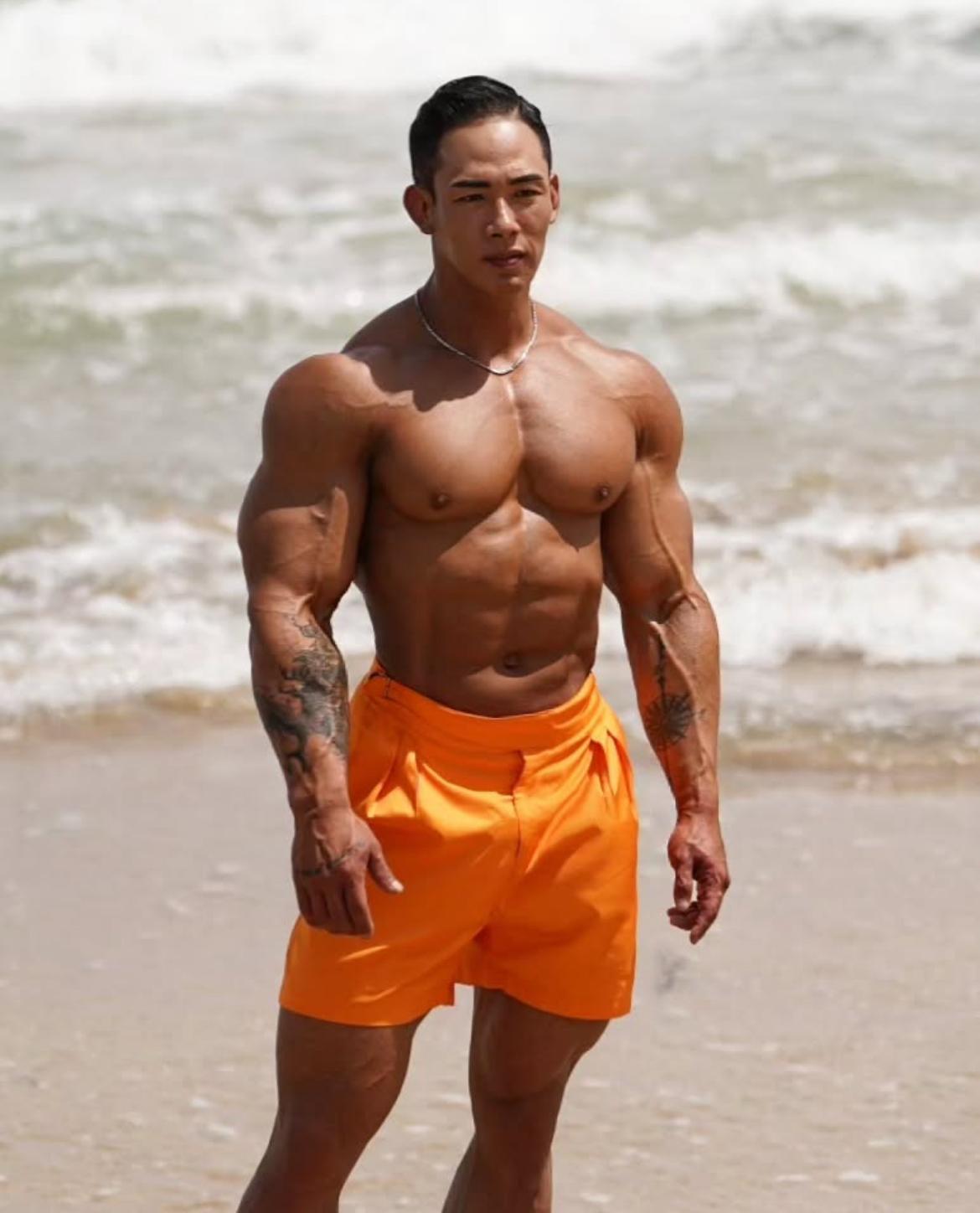 Kim Woong Seo, utilizando shorts anaranjados en la playa