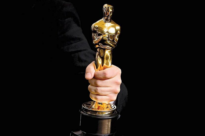 Mano sosteniendo un premio Óscar