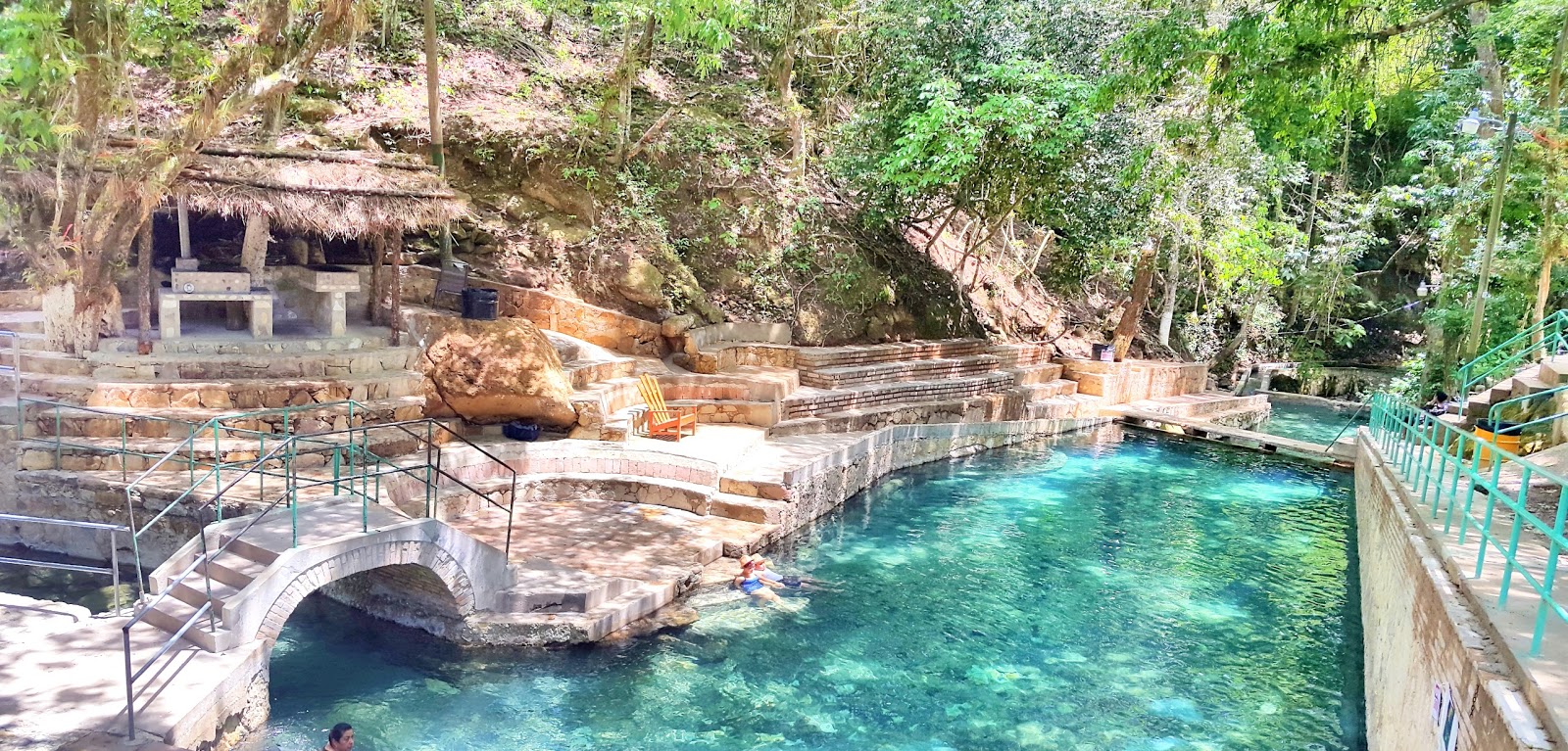 Aguas termales en piscina con un puente pequeño