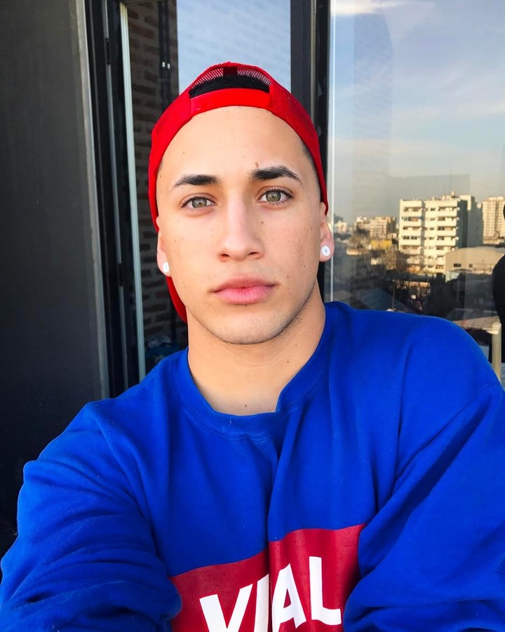 Yao Cabrera utilizando un suéter azul y una gorra roja