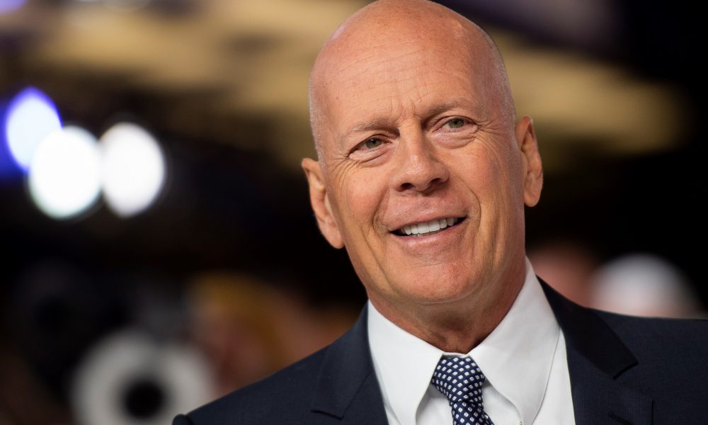 Bruce Willis luciendo un traje negro, wikipedia.
