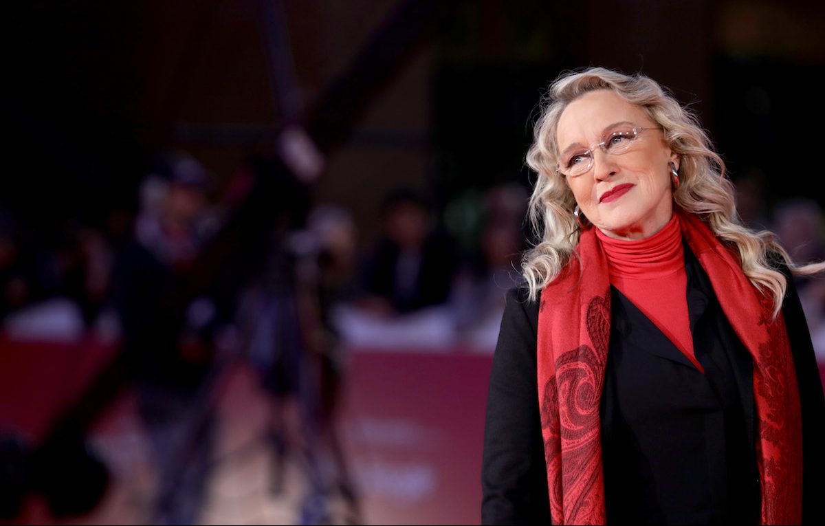 Eleonora Giorgi con un traje negro con una bufanda roja