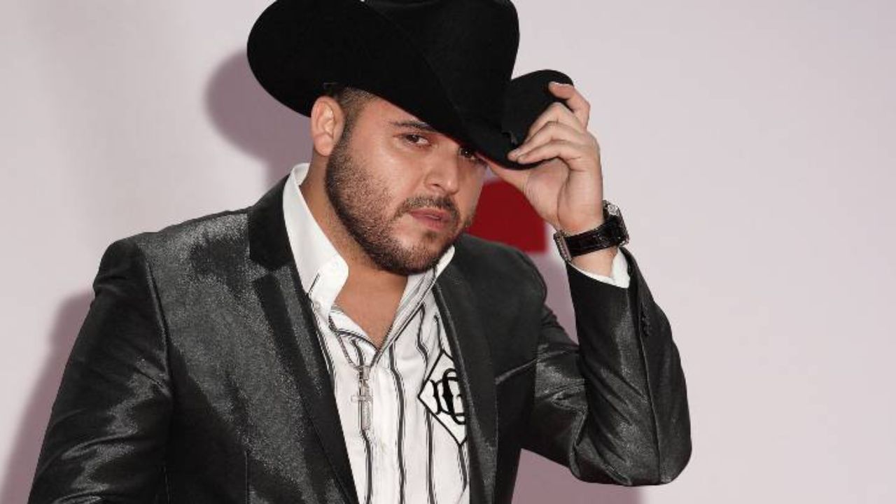 gerardo ortiz de sobrero negro y camisa blanca a rayas