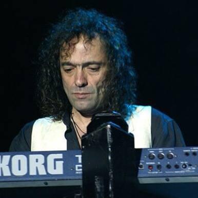 Sergio Cisnero con una camisa negra con blanco tocando el piano.