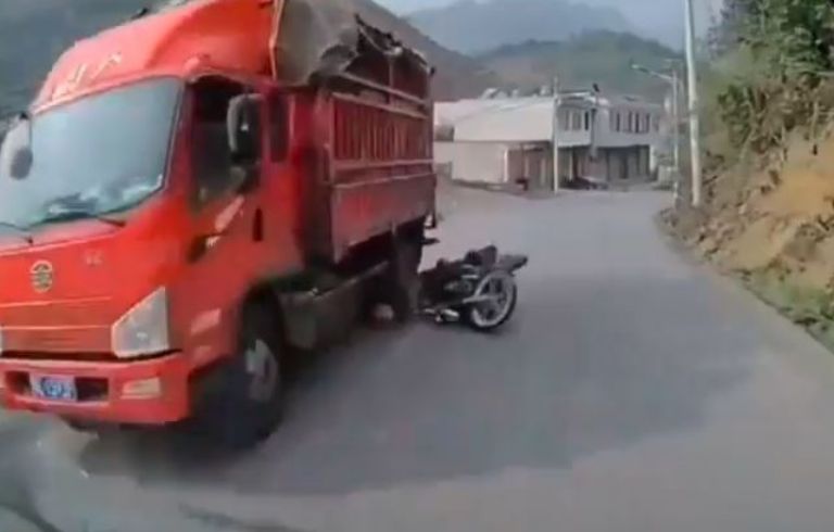 Motociclista a la par de camión que lo aplastó en la carretera.