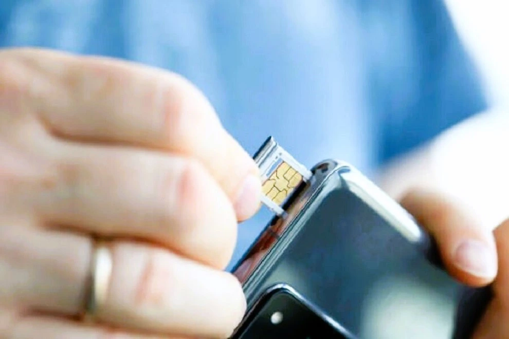 Imagen de una persona introduciendo un chip en un teléfono.