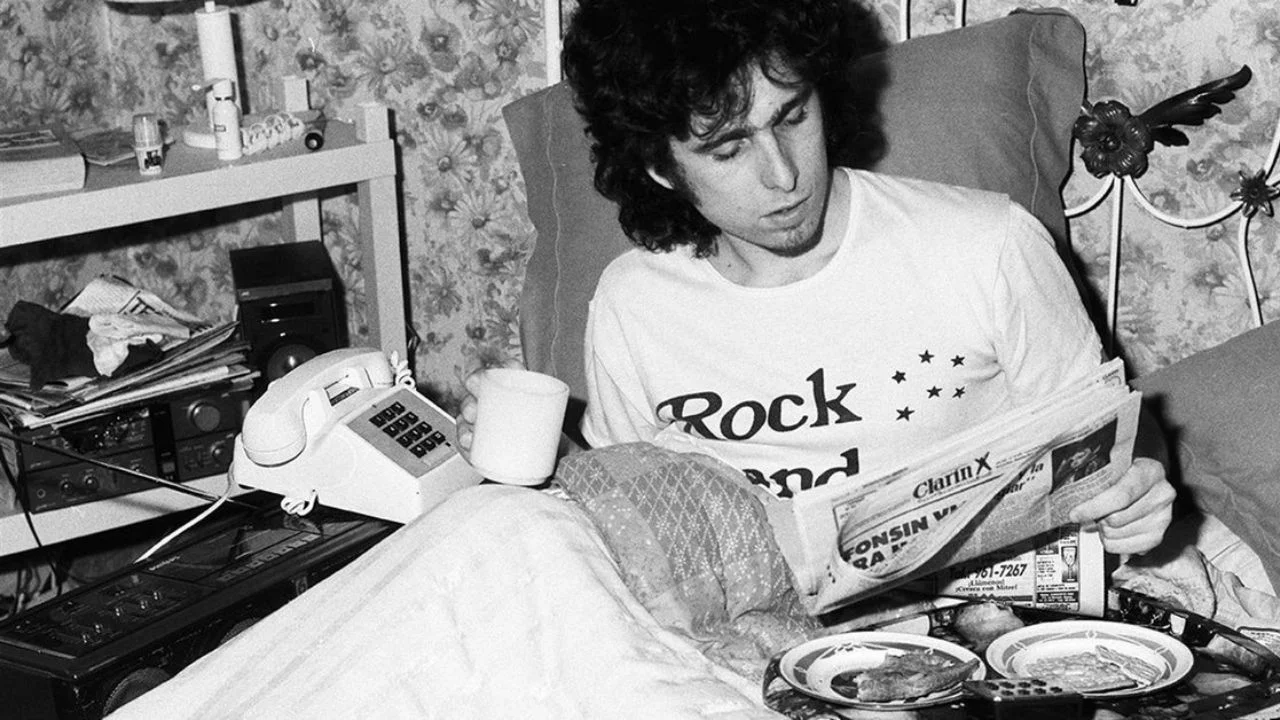 Andrés Calamaro blanco y negro leyendo el periódico