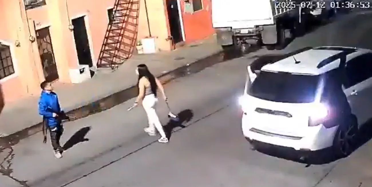 El hombre le apunta a Karla con un arma