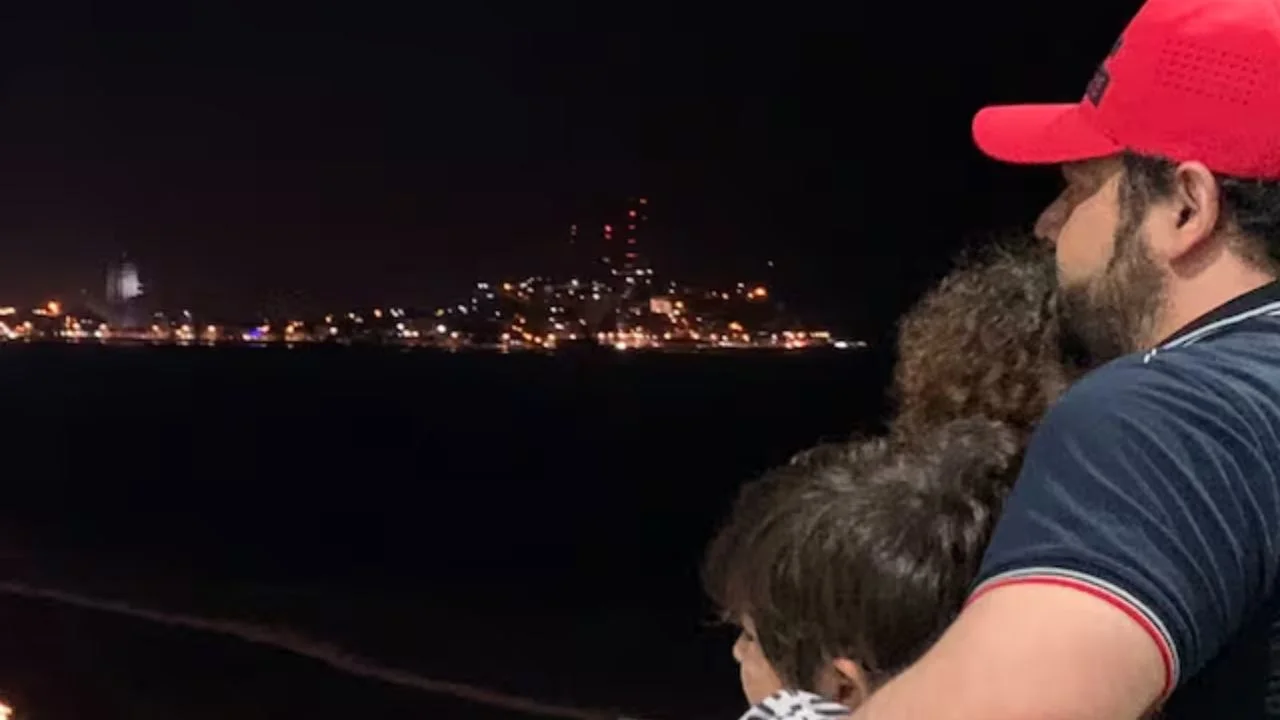 Camilo Ochoa abrazando a dos niños en la noche