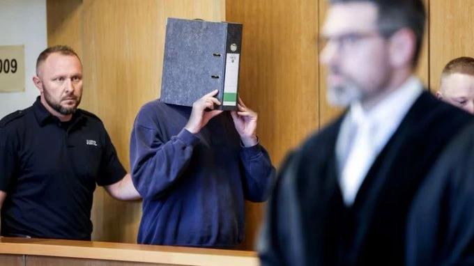 Enfermero oculta su rostro al entrar en la sala del tribunal. Foto: cortesía de CNN