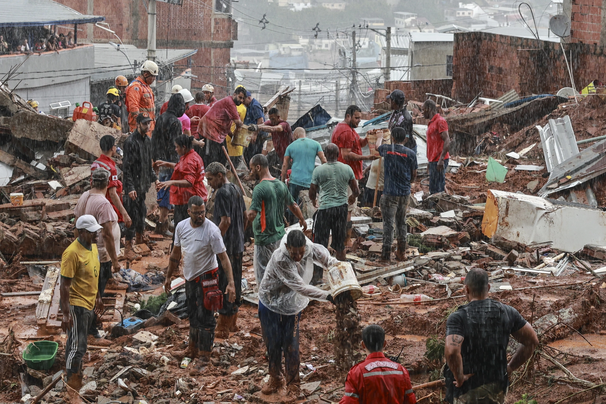 Personas ayudan en labores de rescate y remoción de escombros.