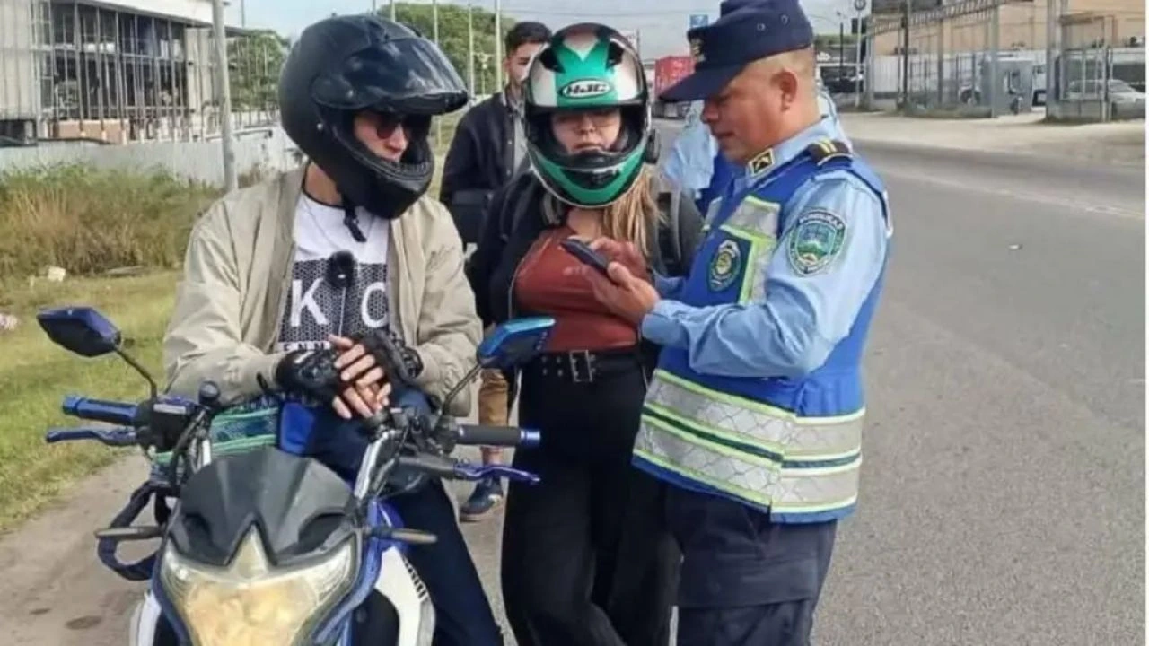 Agente de la DNVT revisando documentación a motocilcistas. 