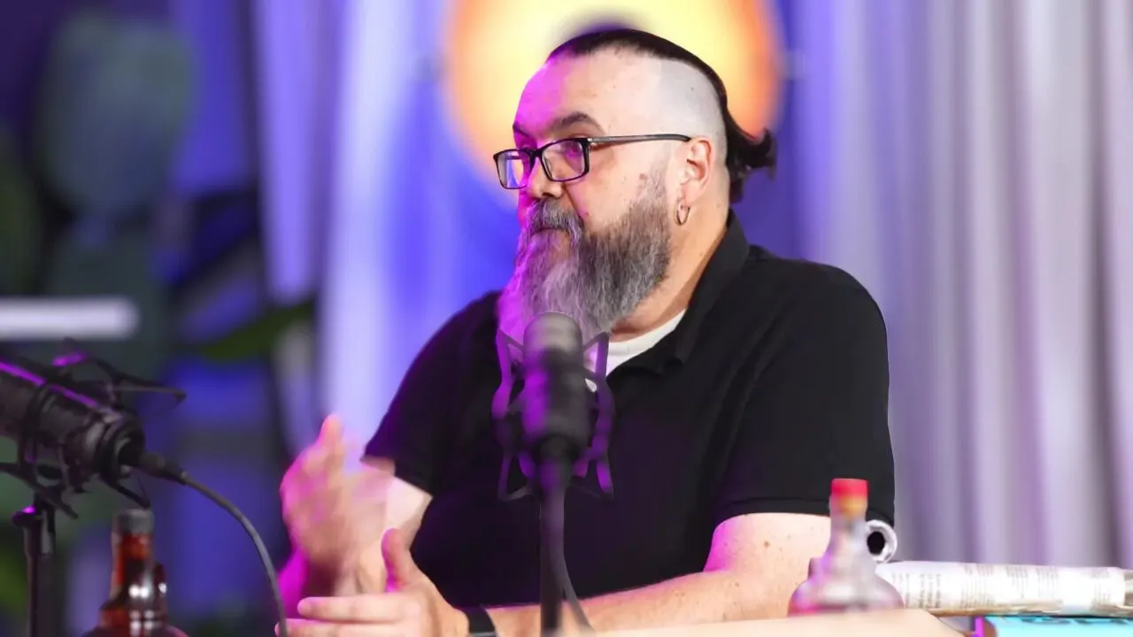 David Pastor Vico vestido con camisa negra y frente a un micrófono. 
