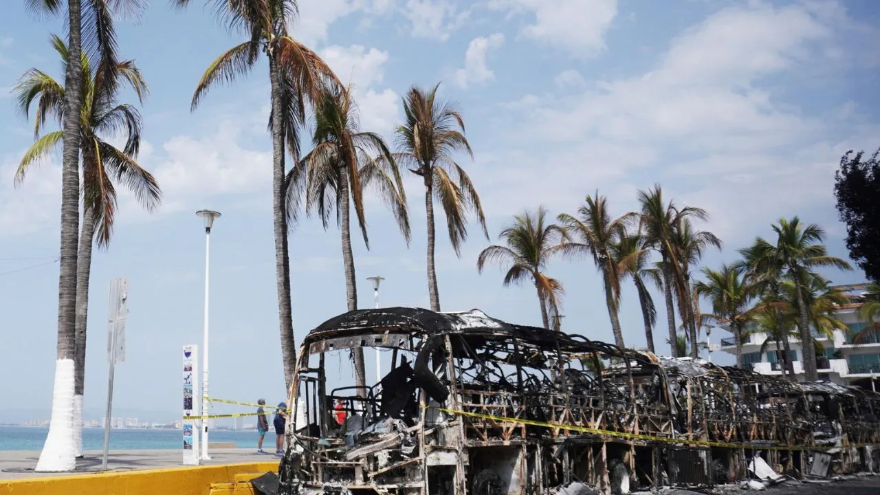 Fotografía que muestra vehículos incendiados este lunes, en el malecón de Puerto Vallarta