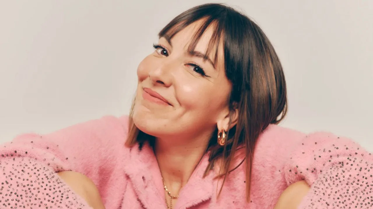 Judith Tiral con un suéter rosado en un fondo blanco.