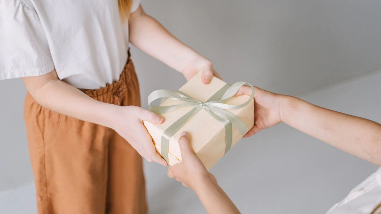 Una persona dando un regalo.