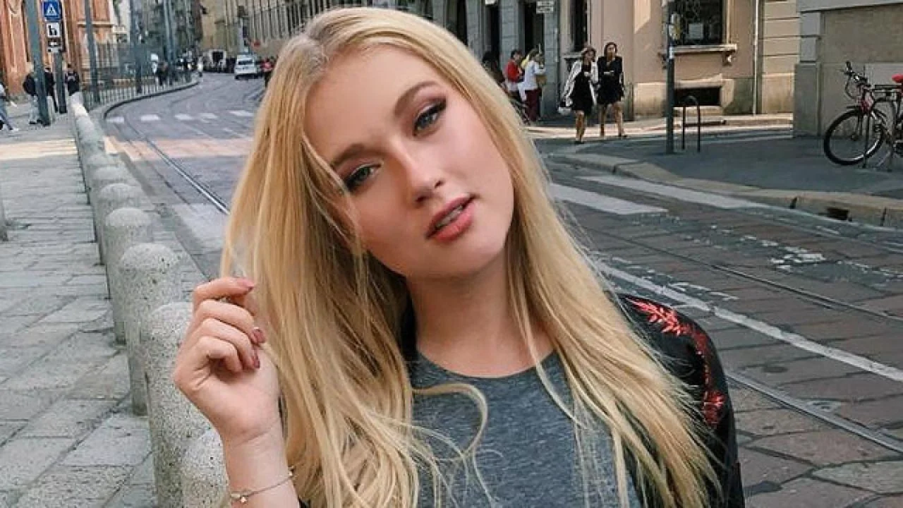 Vesta Lugg con una blusa gris en la calle