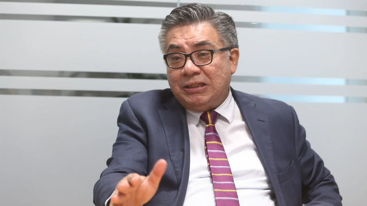 César Nakazaki usando lentes y vestido de traje y corbata.