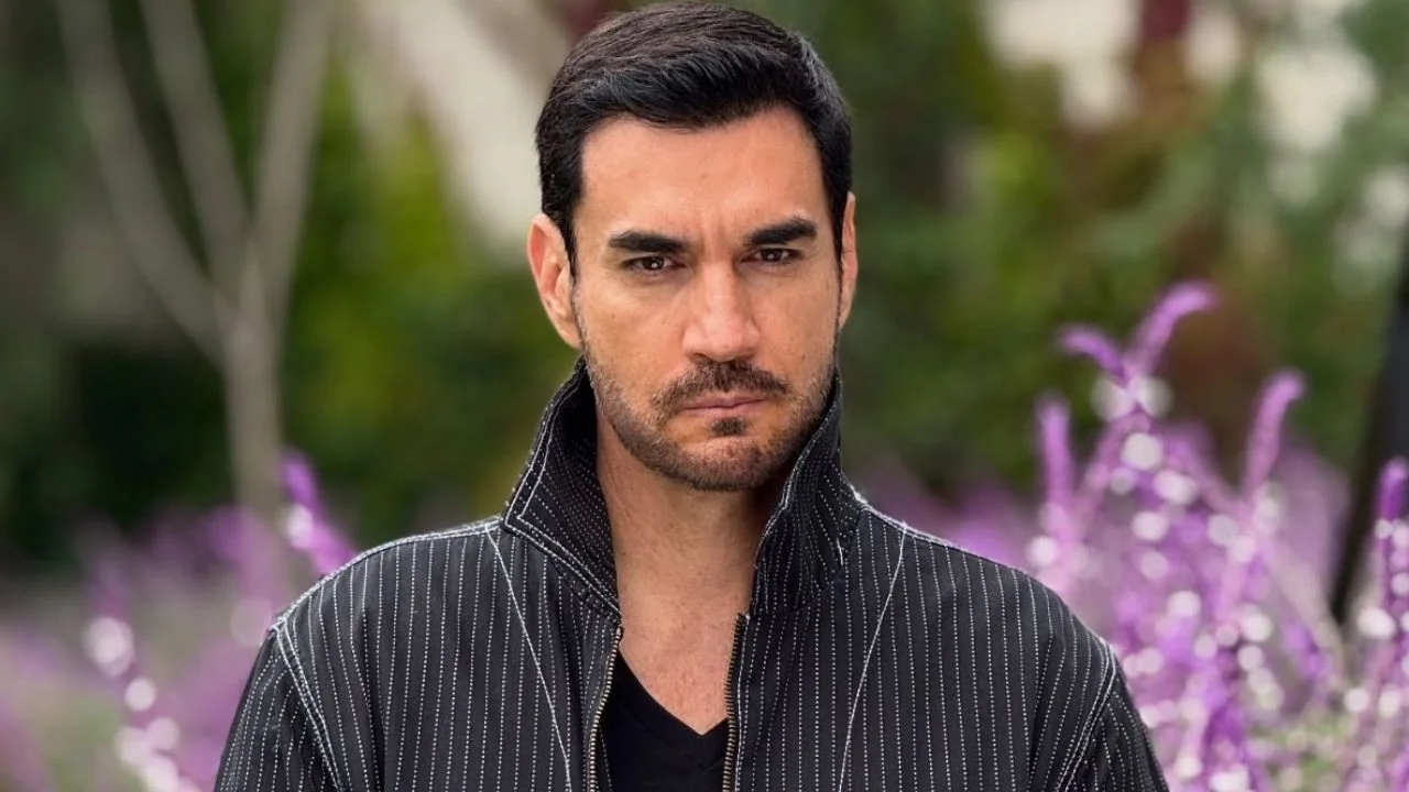 David Zepeda con un suéter negro, con flores en el fondo.