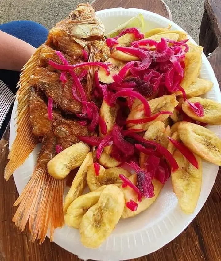 pescado frito servido con tajadas y encurtido