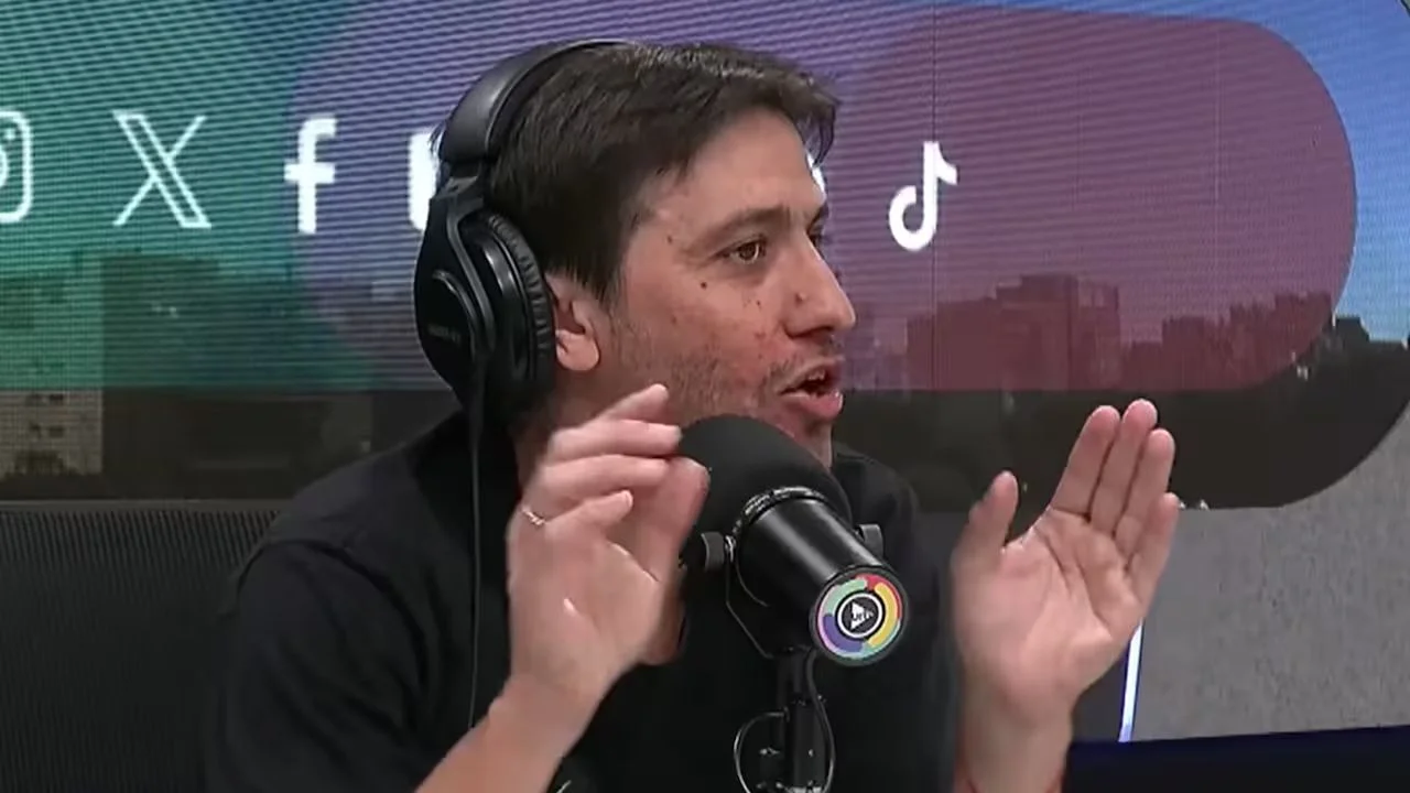 Jairo Straccia con camisa negra frente a un micrófono.