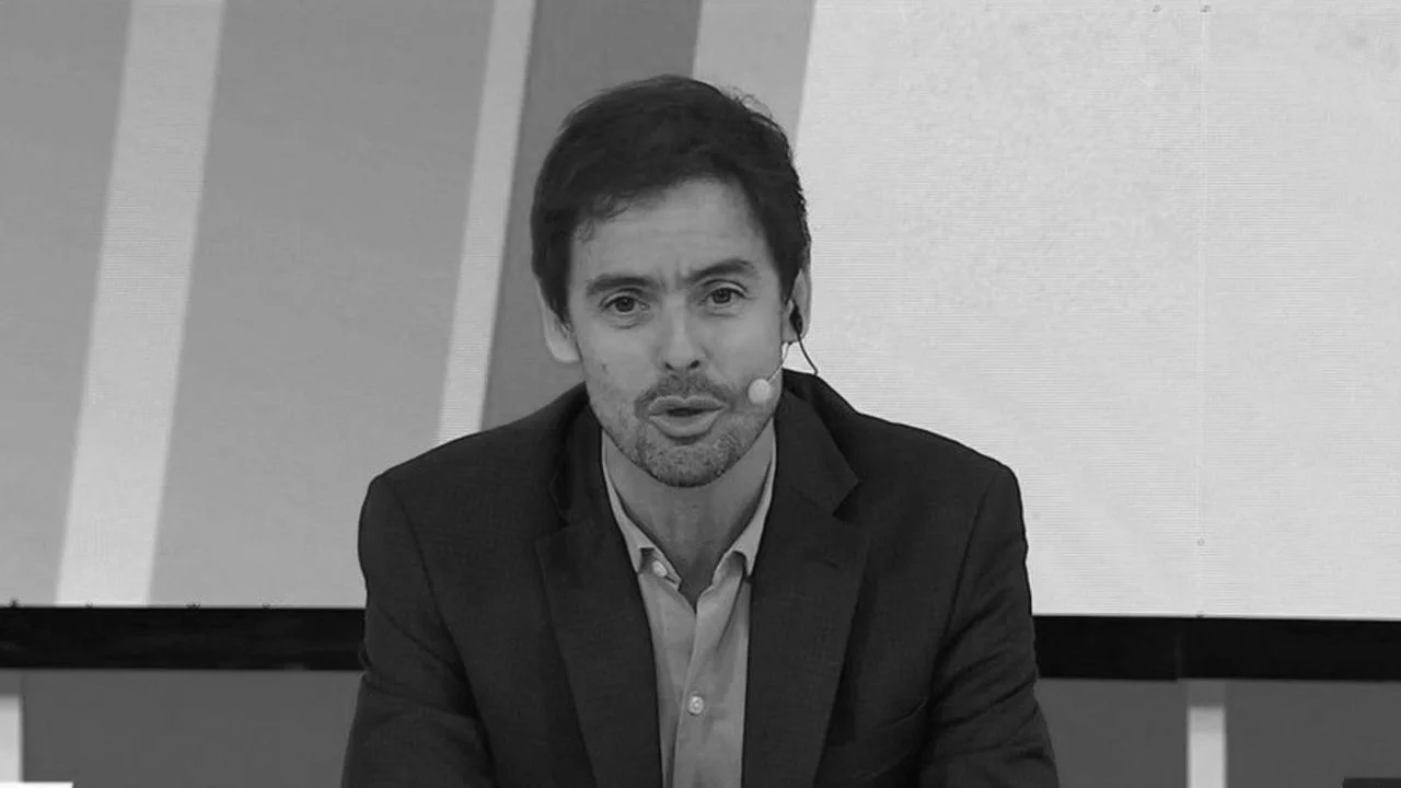 Mariano Closs en estudio de televisión, con micrófono de diadema, participando de un programa en vivo con escenografía sobria y fondo monocromático.