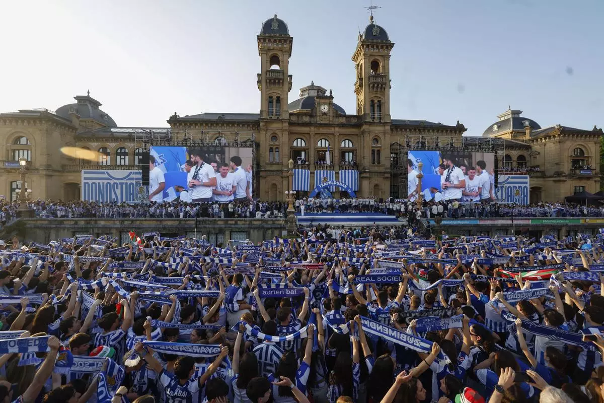 Los jugadores de la Real Sociedad, junto a aficionados celebran la victoria en la final Copa del Rey, este lunes en San Sebastián.