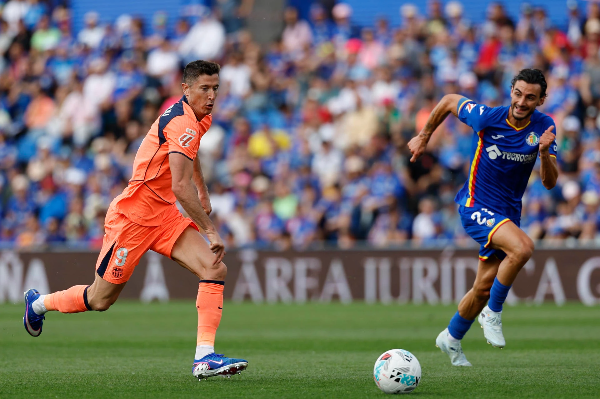 El defensa del Getafe Juan Iglesias disputa un balón con el delantero del FC Barcelona Robert Lewandowski. 