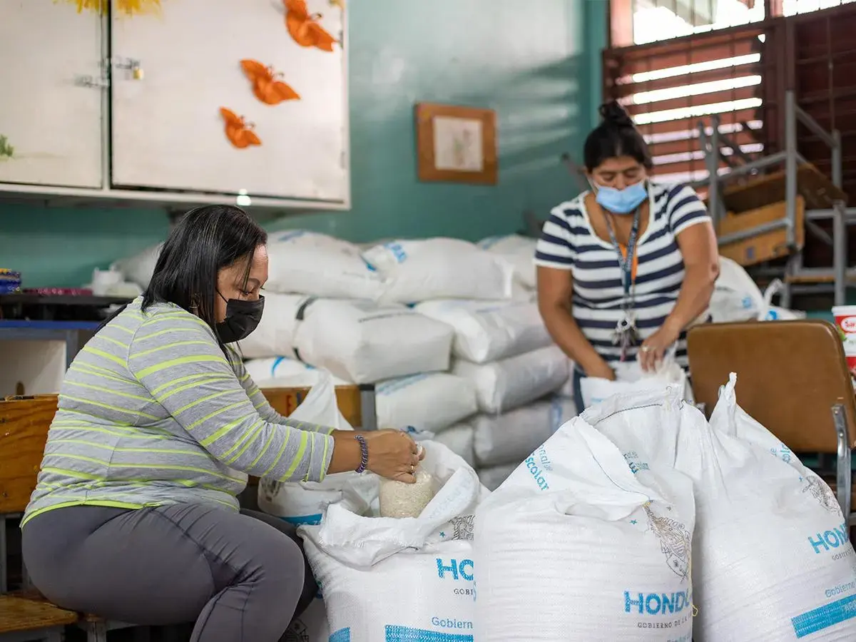 mujeres amarrando sacos