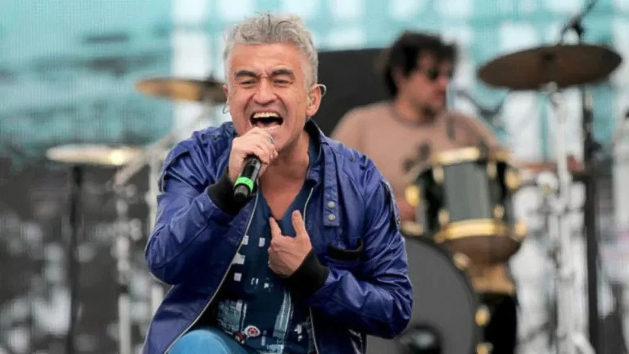 Jorge González en un escenario cantando.