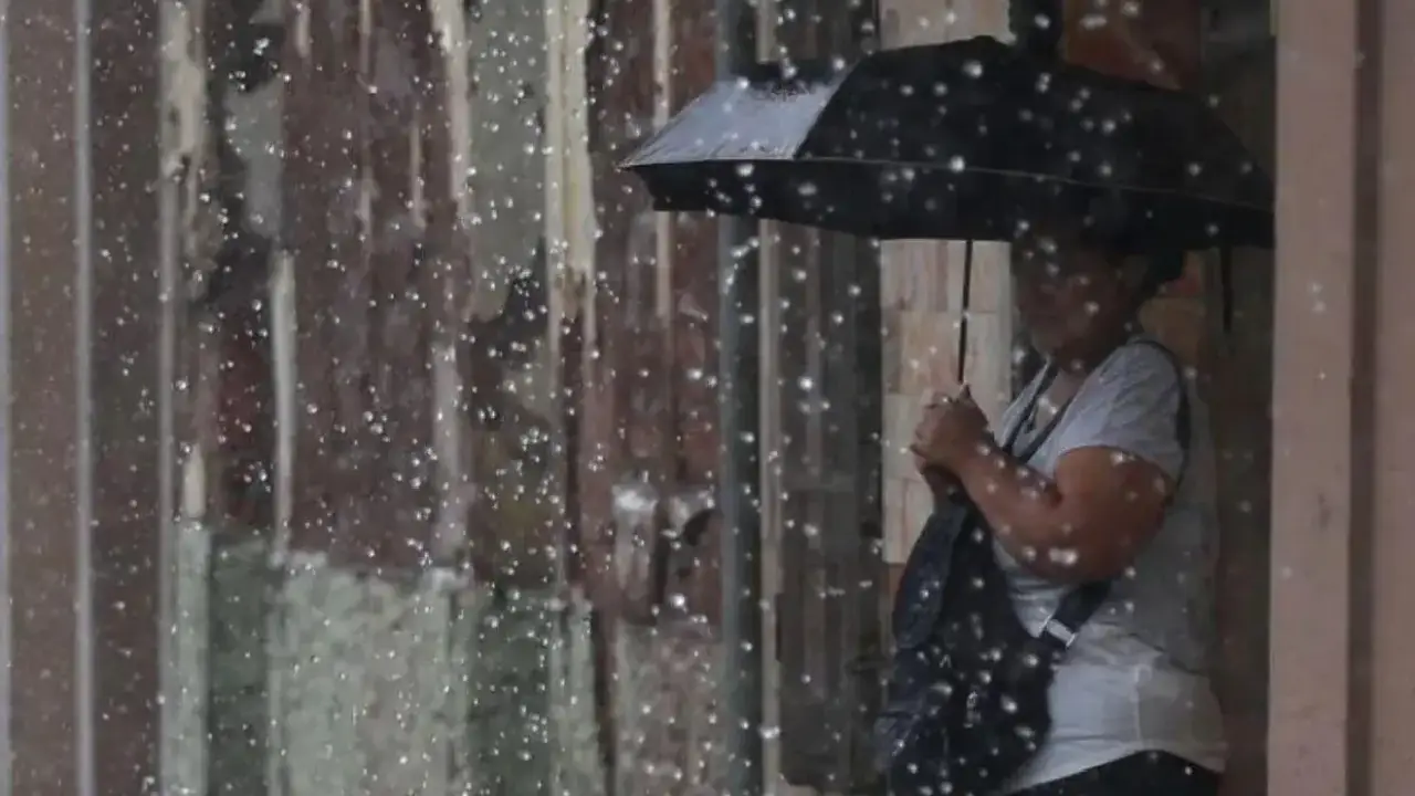 Una mujer se protege de una lluvia en Tegucigalpa