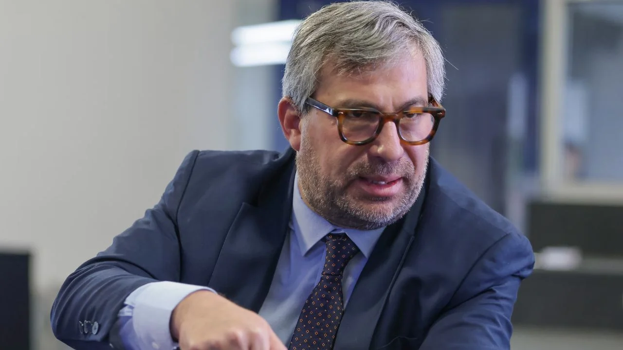 Piero Corvetto sentado y vestido de saco y corbata.