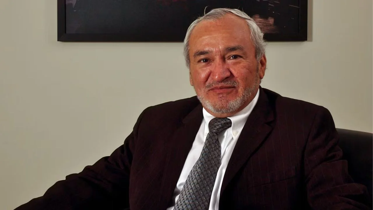 Samuel Dyer sentado y vestido de saco y corbata.