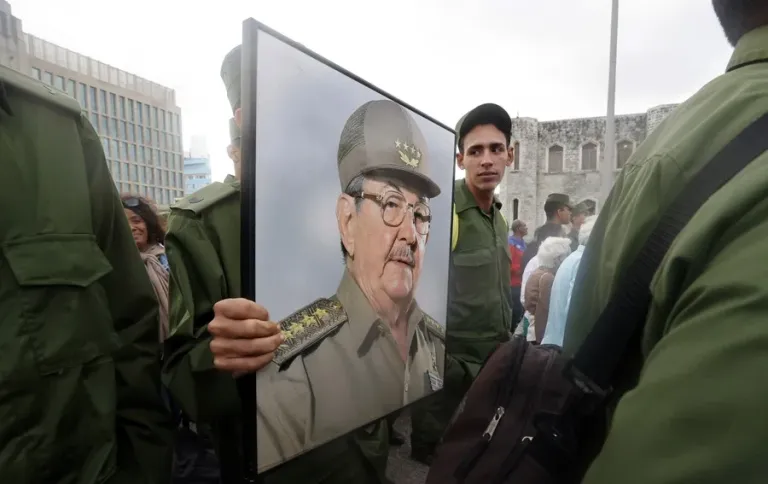 Fotografía de archivo de integrantes de las Fuerzas Armadas de Cuba que sostienen un cartel con la imagen de Raúl Castro. 