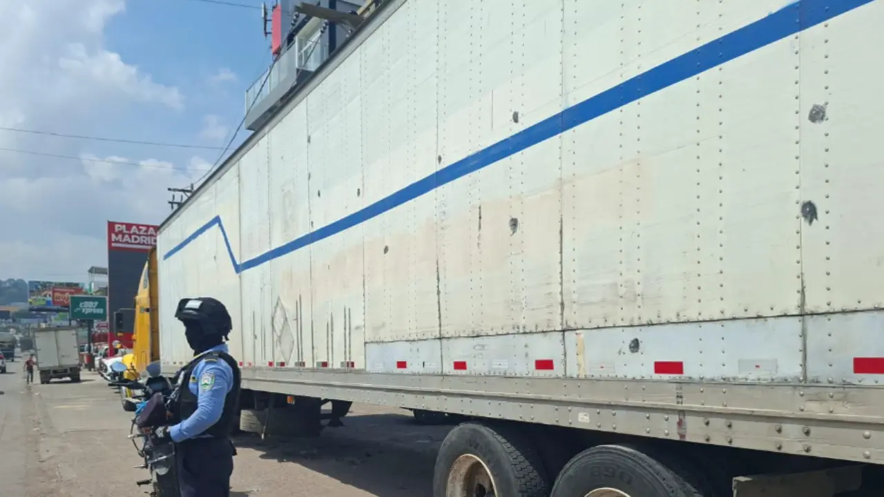 Una rastra estacionada, al lado un agente de policía